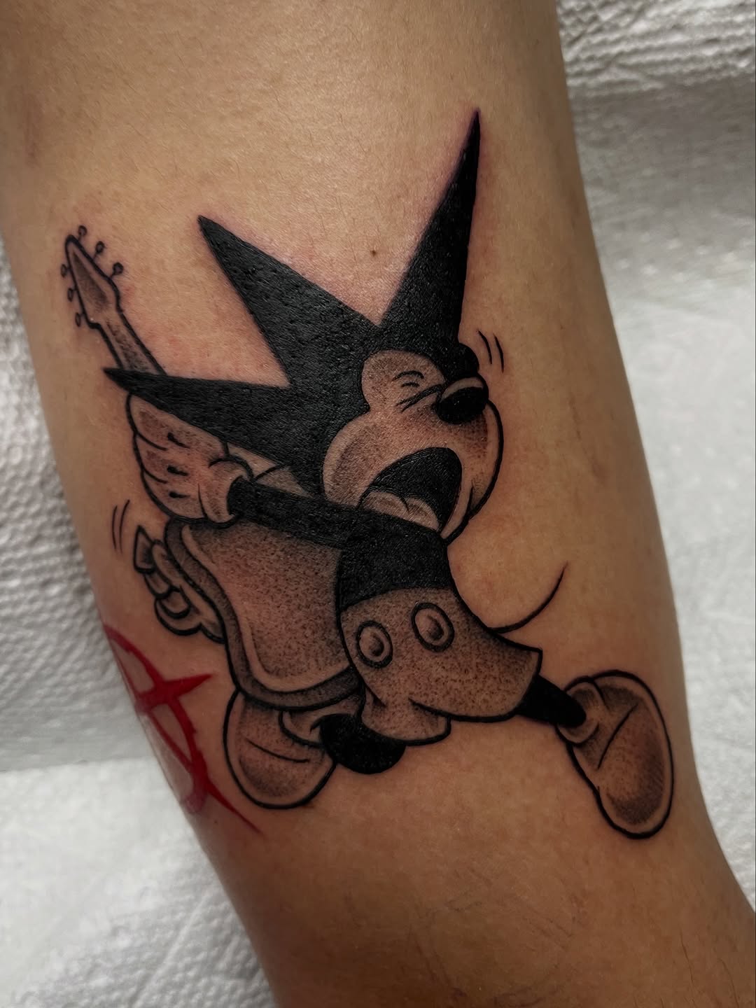 Bold black rock and roll Mickey Mouse with guitar tattoo