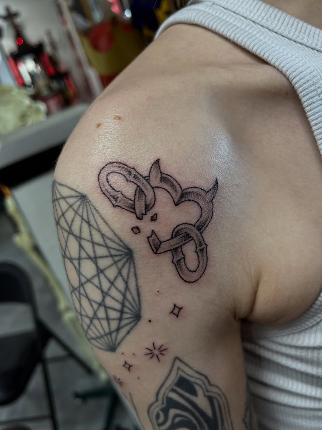 Fine line devil heart with snake tattoo on shoulder